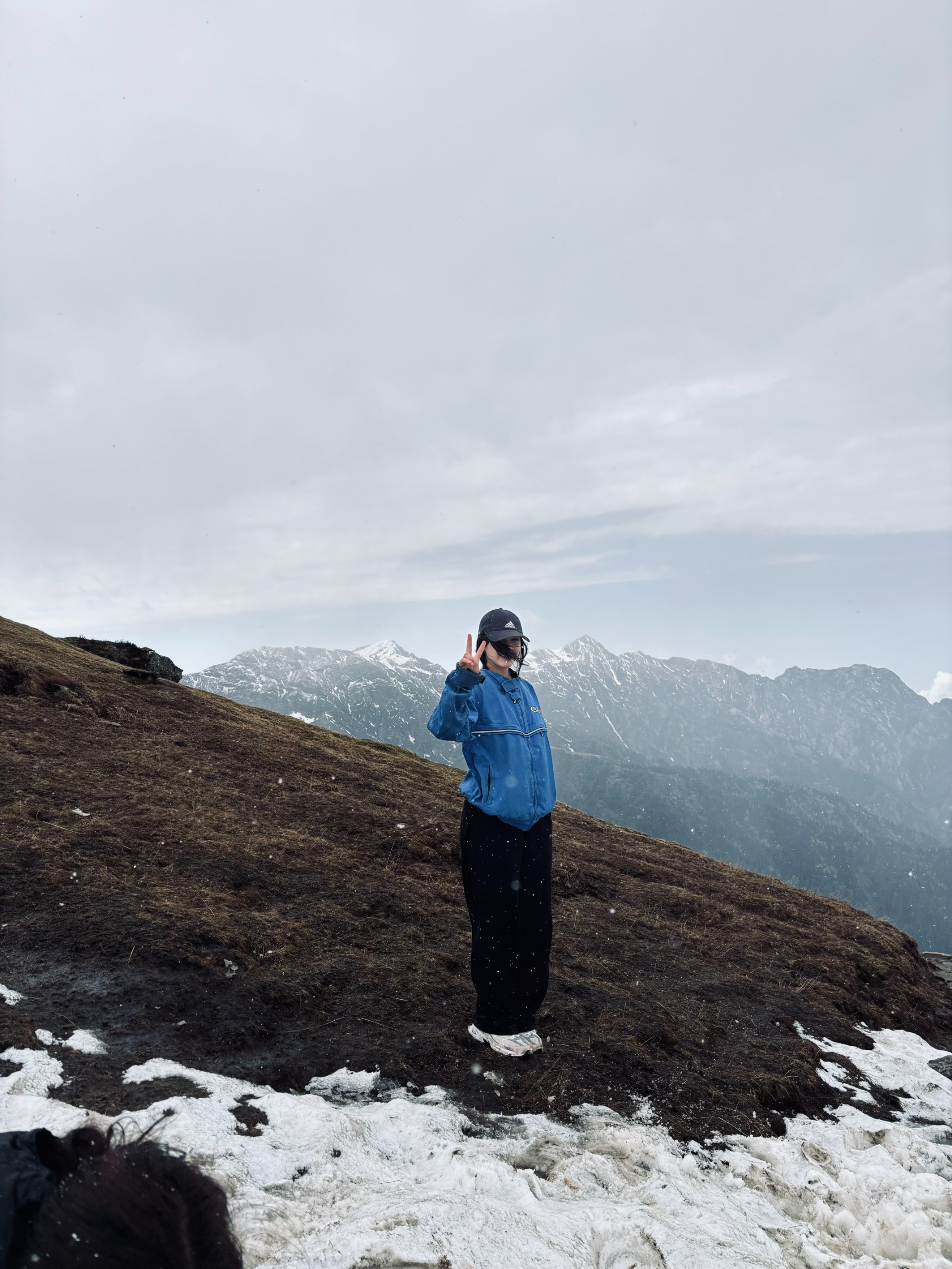 Shalika in a blue jacket on a snowy Himalayan ridge